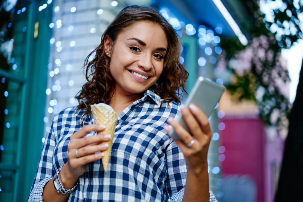 Easy recipe: How to make homemade sorbet cheerful hipster girl with gelato sorbet and modern cellphone gadget smiling