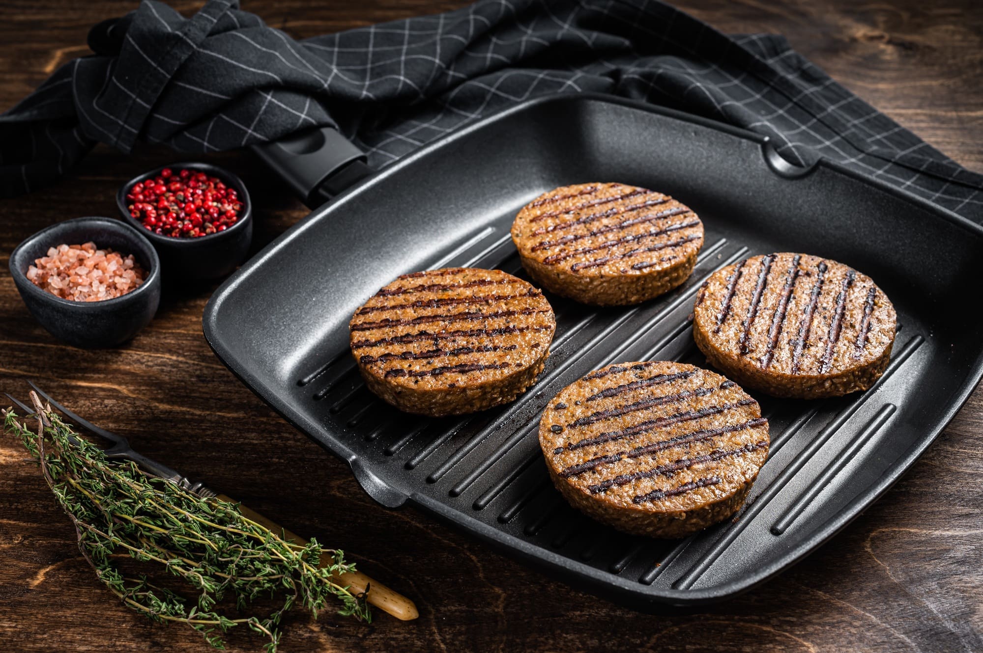 Grilled Vegetarian plant-based meat burger patties, vegan cutlets on grill skillet.