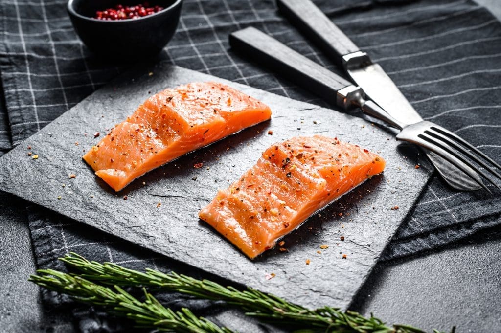 10 recipes with 5 ingredients, 15 minutes and it's ready! Fillet salmon steak on a stone Board. Black background. Top view